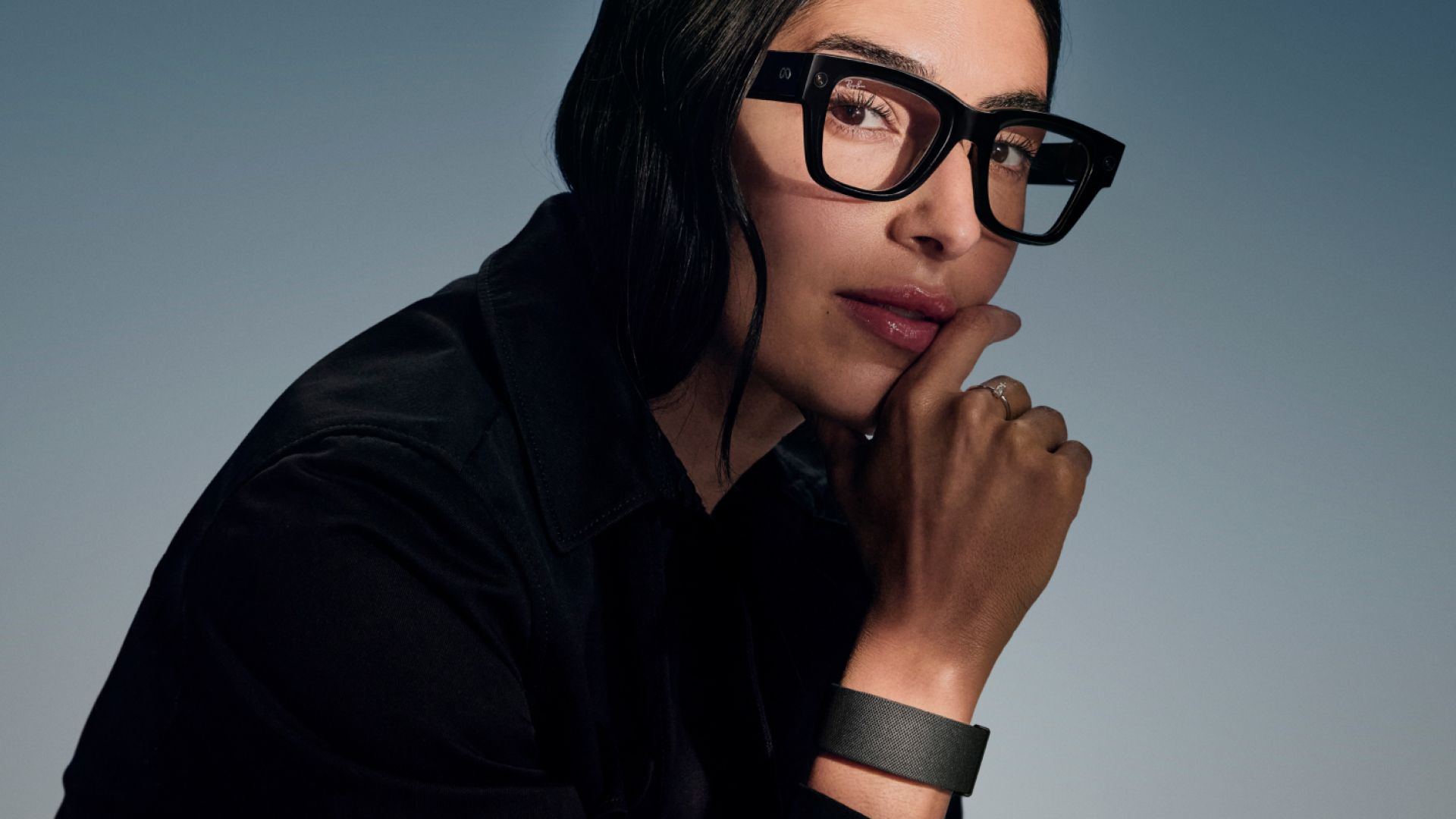 Eine Frau trägt die Meta Ray-Ban Display mit schwarzem Rahmen und das Neural Band am Handgelenk