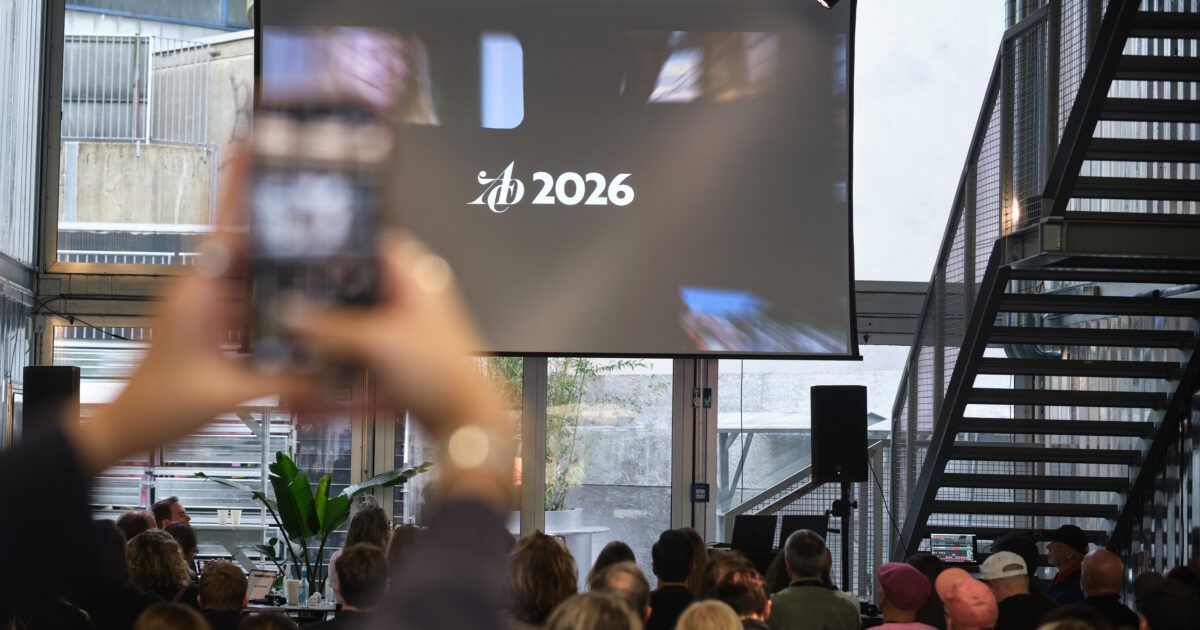 Publikum der ADC-Jahreshauptversammlung von hinten vor einer Leinwand mit ADC-Logo und der Jahreszahl 2026